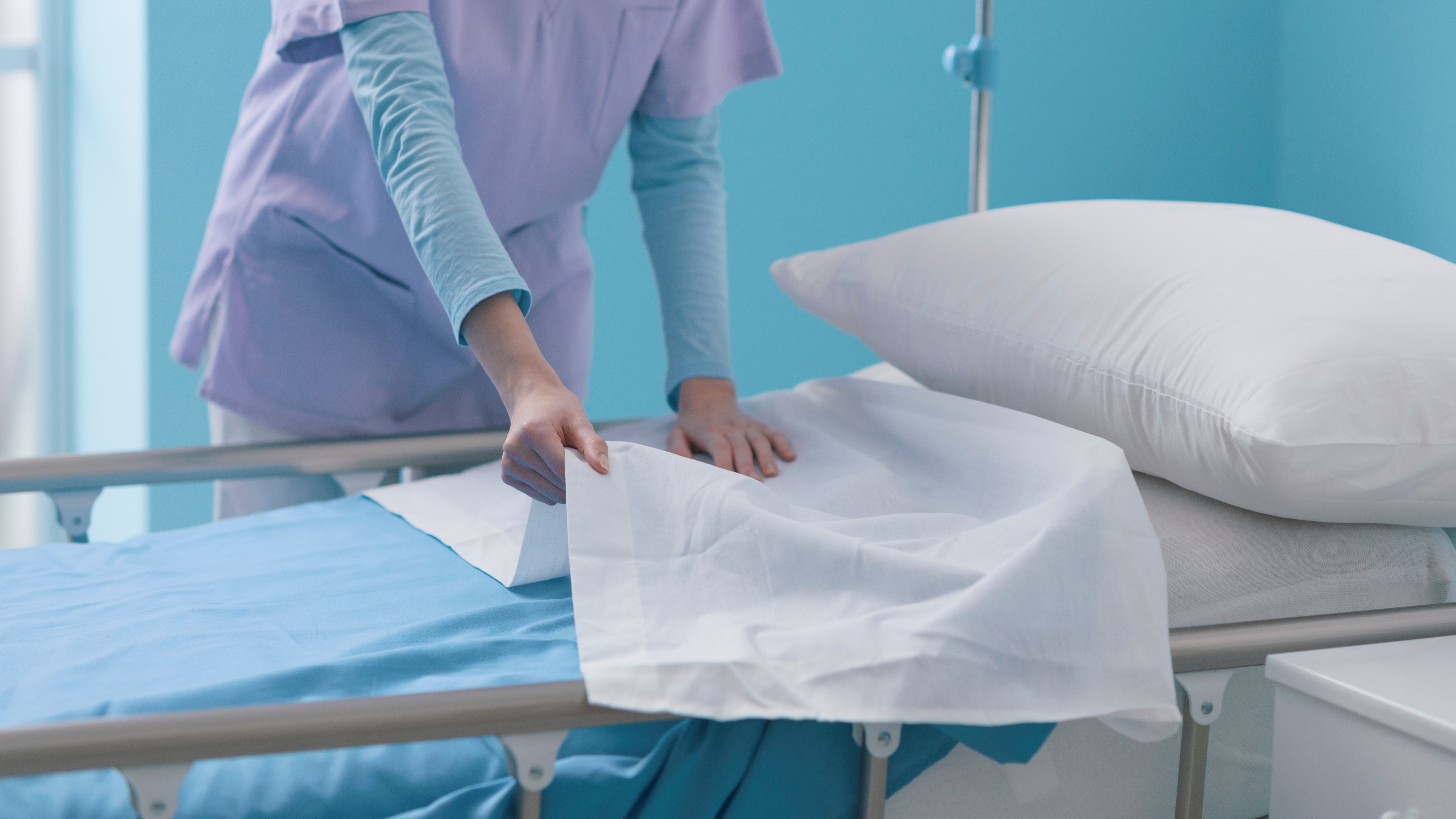 expert-young-nurse-making-the-bed-at-the-hospital-2022-02-02-04-50-37-utc