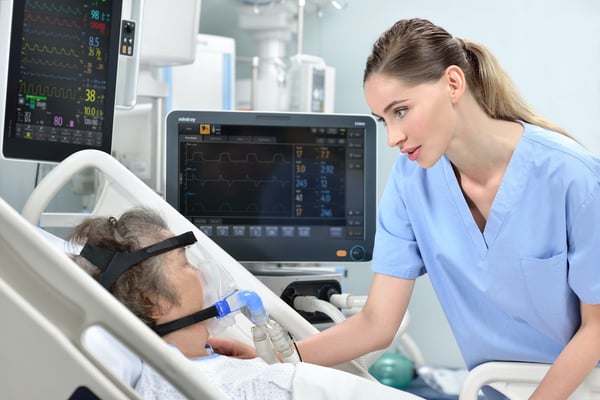  Nurse at patient bedside considers pressure injury prevention and treatment options for patient with head in brace on oxygen